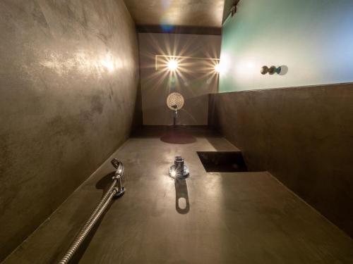 a bathroom with a shower with a sink and a spotlight at Paradise Resort in Finikounta