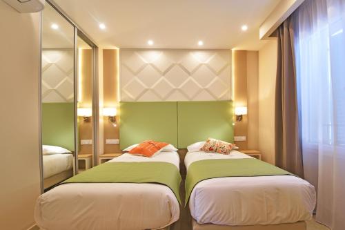 two beds in a room with green and white at Résidence Saint-Jean in Saint-Florent