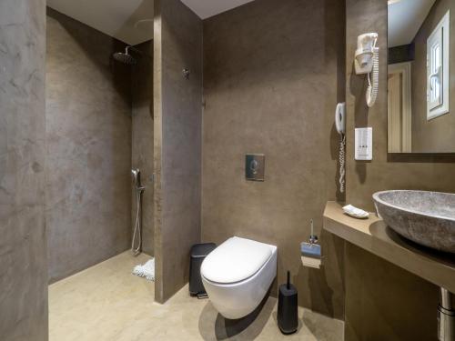 a bathroom with a toilet and a sink at Paradise Resort in Finikounta