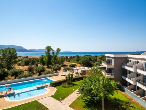 an apartment with a swimming pool and the ocean at Paradise Resort in Finikounta