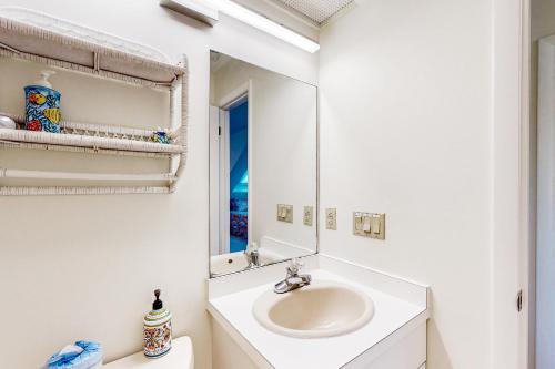 a white bathroom with a sink and a mirror at Kings Grant --- 40097 E Oceanside Unit 21 in Fenwick Island