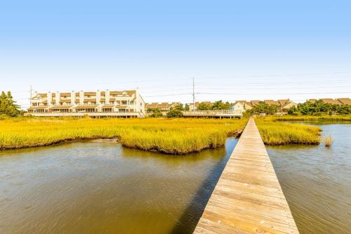 a wooden bridge over a river with buildings in the background at Kings Grant --- 40097 E Oceanside Unit 21 in Fenwick Island