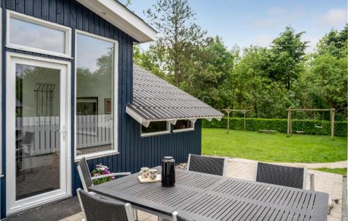 a blue house with a table and chairs on a patio at Nice Home In Toftlund With Wifi in Toftlund
