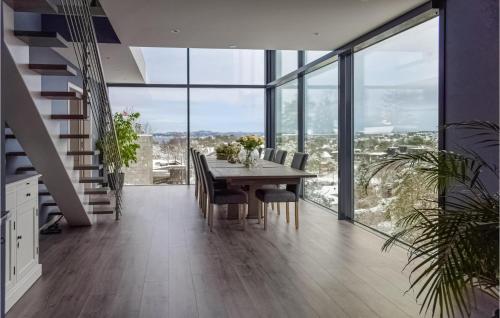 a dining room with a table and chairs and windows at Nice Home In Sandefjord With Wifi in Sandefjord