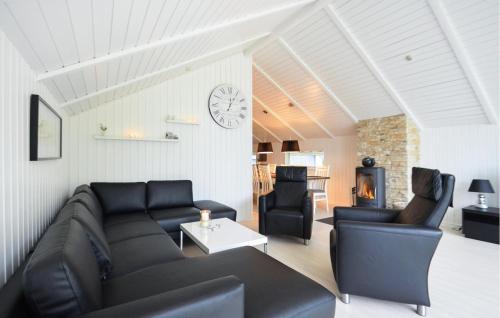 a living room with a couch and chairs and a clock at Four-Bedroom Holiday Home In Spottrup in Spottrup