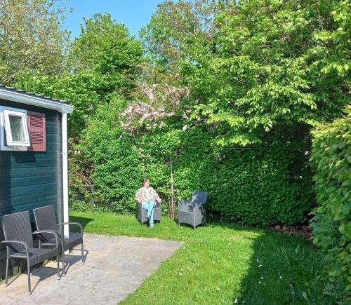a woman sitting in a chair in a yard at Gemütliches Chalet mit Terrasse in Baarland