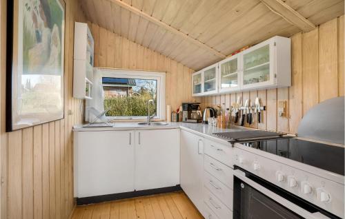 a kitchen with white cabinets and a window at Holiday Home Humlevænget Hejls V in Hejls