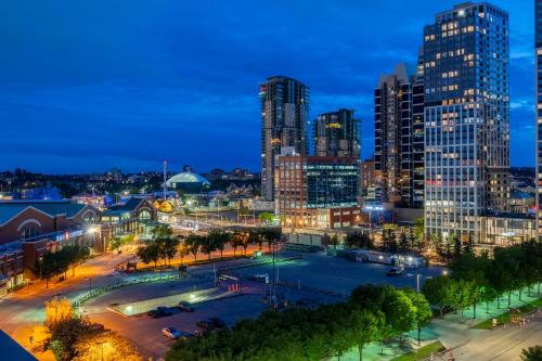 a view of a city at night at "The Draper" - Luxury Corner Unit w Tower View, - Near Stampede, Saddledome, BMO Centre! FREE Parking, Banff Pass, & Wine! in Calgary