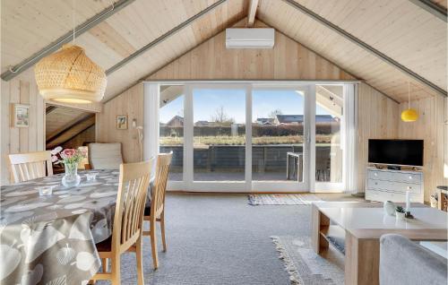 a dining room with a table and a large window at Holiday Home Skovløkken Hejls Vi in Hejls
