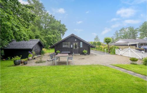a backyard with a black house with a table and chairs at Amazing Home In Haderslev With Wifi in Haderslev
