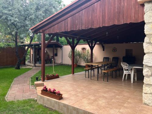 a pavilion with a table and chairs on a patio at Tőserdei Vendégház in Lakitelek