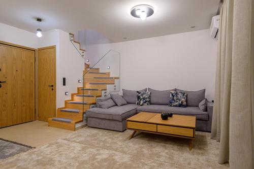 a living room with a couch and a staircase at Next Vision Residence in Anatolí