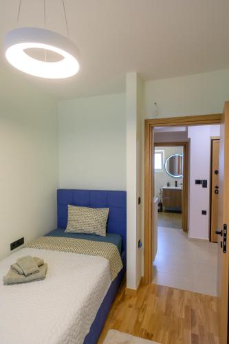 a bedroom with a bed with a blue headboard at Next Vision Residence in Anatolí