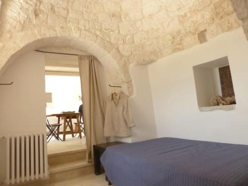 a bedroom with a bed and an arched doorway at Trullo dell'Upupa in Ostuni