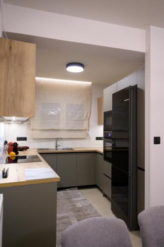 a kitchen with a black refrigerator and a counter at Next Vision Residence in Anatolí