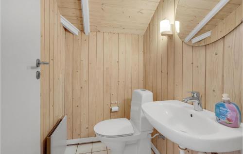 a bathroom with a white toilet and a sink at Holiday Home Vestertoften in Høruphav