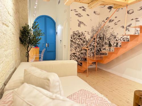 un soggiorno con porta blu e scale di Elpis Guest House a Himare