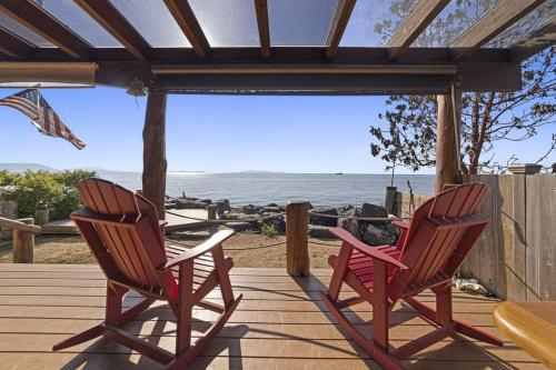 two chairs sitting on a deck with a view of the ocean at New Beautiful Waterfront at Sandy Point in Ferndale