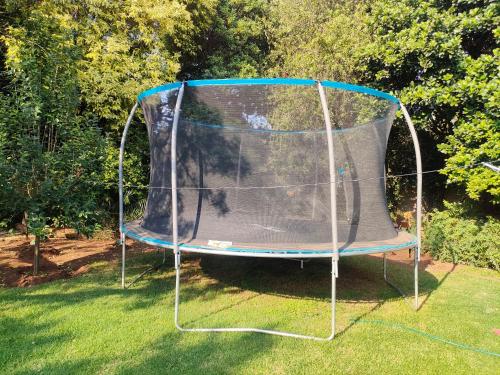 a trampoline in the grass in a yard at Lipizzaner Lodge - Kyalami, Midrand in Kyalami