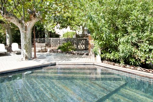 una piscina in un cortile alberato di Bed and Breakfast La Grande Lauzade a Le Luc