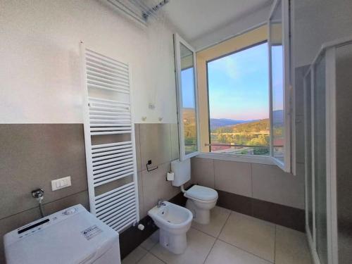 a bathroom with a toilet and a window at Appartamento Da Cesare a Porretta Terme Centro in Porretta Terme