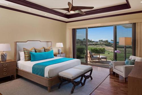 a bedroom with a large bed and a balcony at Hale Keanu in Hapuna Beach
