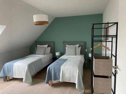 deux lits dans une chambre aux murs verts dans l'établissement Villa Beau Séjour, à Fontenay-sur-Mer