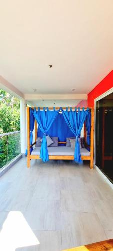 a bedroom with a bunk bed with blue curtains at Blue Mango Beach Hotel in Guachaca