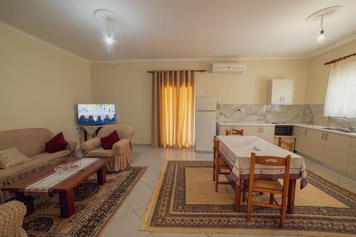 a living room with a table and a kitchen at Home Sweet Home A Quiet,Spacious Two-Bedroom house in Dërmish