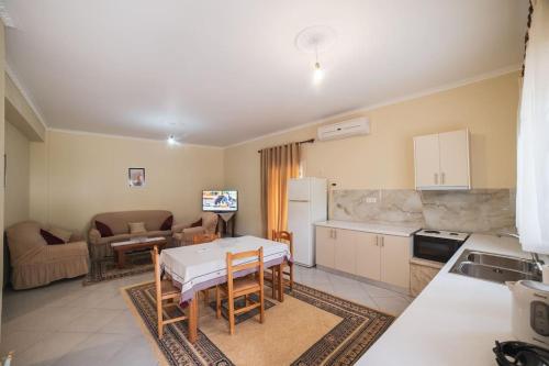 a kitchen and living room with a table and chairs at Home Sweet Home A Quiet,Spacious Two-Bedroom house in Dërmish