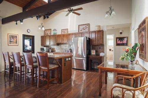 a kitchen with a refrigerator and wooden cabinets at Hale Mauka in Captain Cook