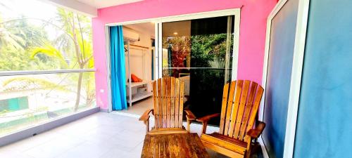 two chairs sitting on the porch of a house at Blue Mango Beach Hotel in Guachaca