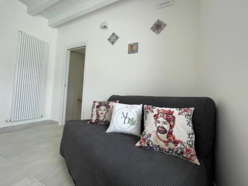 a couch with pillows on it in a room at Maison Divaga in Fleri