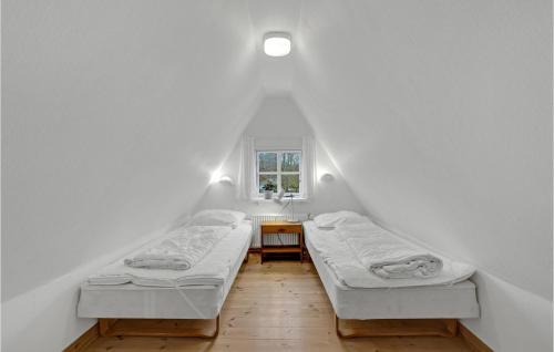 two beds in a room with a window at Two-Bedroom Holiday Home In Krusa in Kruså