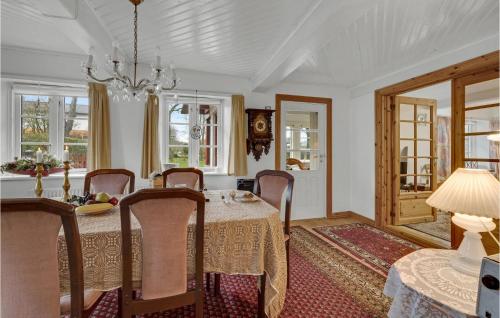 a dining room with a table and chairs and a chandelier at Two-Bedroom Holiday Home In Krusa in Kruså