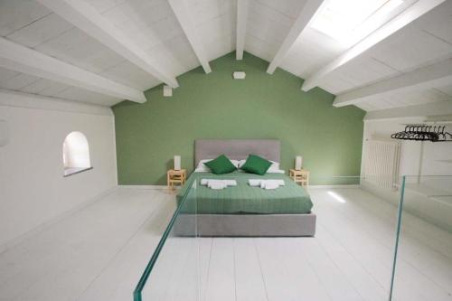 a green room with a bed and two chairs at Maison Divaga in Fleri