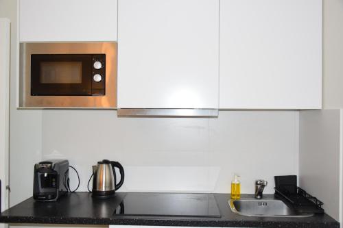 une cuisine avec un évier et un micro-ondes dans l'établissement Quiet Tiny Apartment, à Versailles