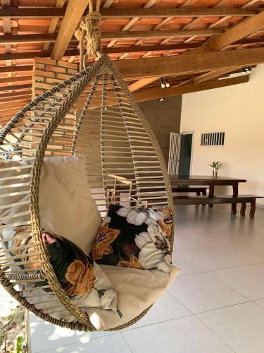 a hanging hammock chair with pillows in a room at Amaro Residence in Santo Amaro