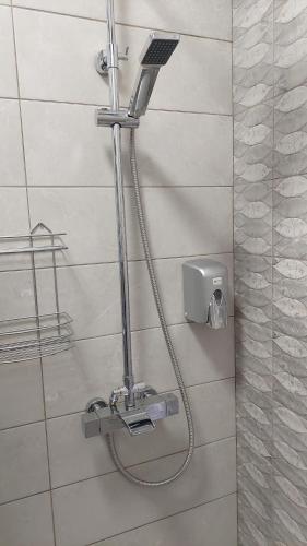 a shower with a hose attached to a wall at La Rascu 1 in Oradea
