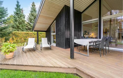 a wooden deck with a table and chairs on a house at Three-Bedroom Holiday Home In Vaggerlose in Marielyst