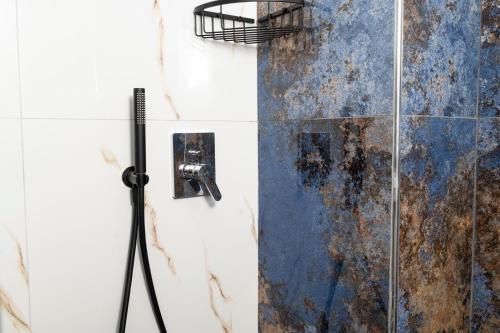 a shower with a rusty wall and a metal shower at Poseidon 5 in Paralia Katerinis