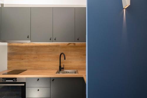 a kitchen with white cabinets and a sink at Poseidon 5 in Paralia Katerinis