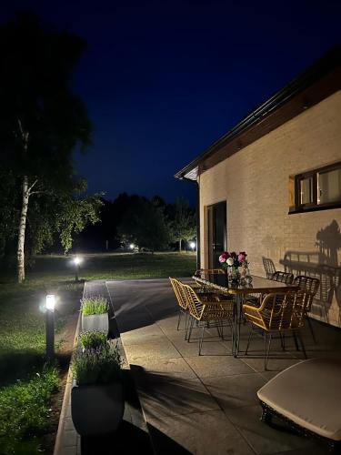 a patio with a table and chairs at night at ANDO Villa with wood stove sauna in Selgas