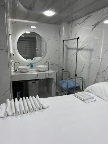 a bathroom with a white bed and a mirror at Hotel Orduz Centro Histórico de Cali in Cali