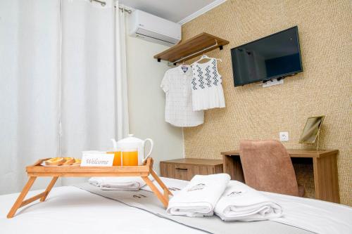 Camera con letto, tavolo e TV di Finesse Comfort Apartments a Keramotí