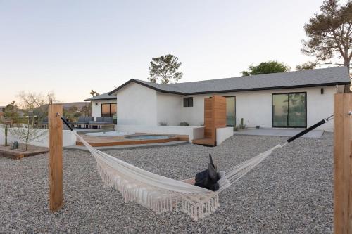 a house with a hammock in front of it at Villa Yoku By The Cohost Company in Yucca Valley