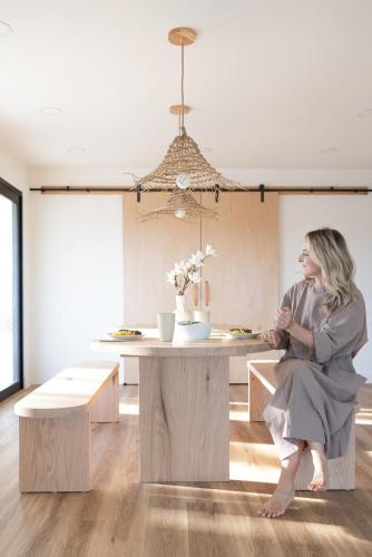 a woman sitting at a table in a room at Villa Yoku By The Cohost Company in Yucca Valley