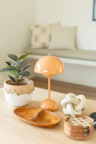 a table with a lamp and a plant on it at Villa Yoku By The Cohost Company in Yucca Valley