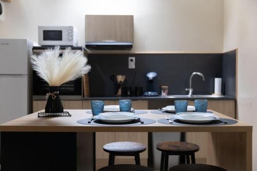 une cuisine avec table et verres bleus dans l'établissement Studio en vieille ville avec chambre en mezzanine, à Boulogne-sur-Mer