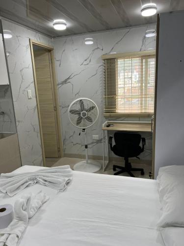 a bedroom with a bed and a desk and a fan at Hotel Orduz Centro Histórico de Cali in Cali